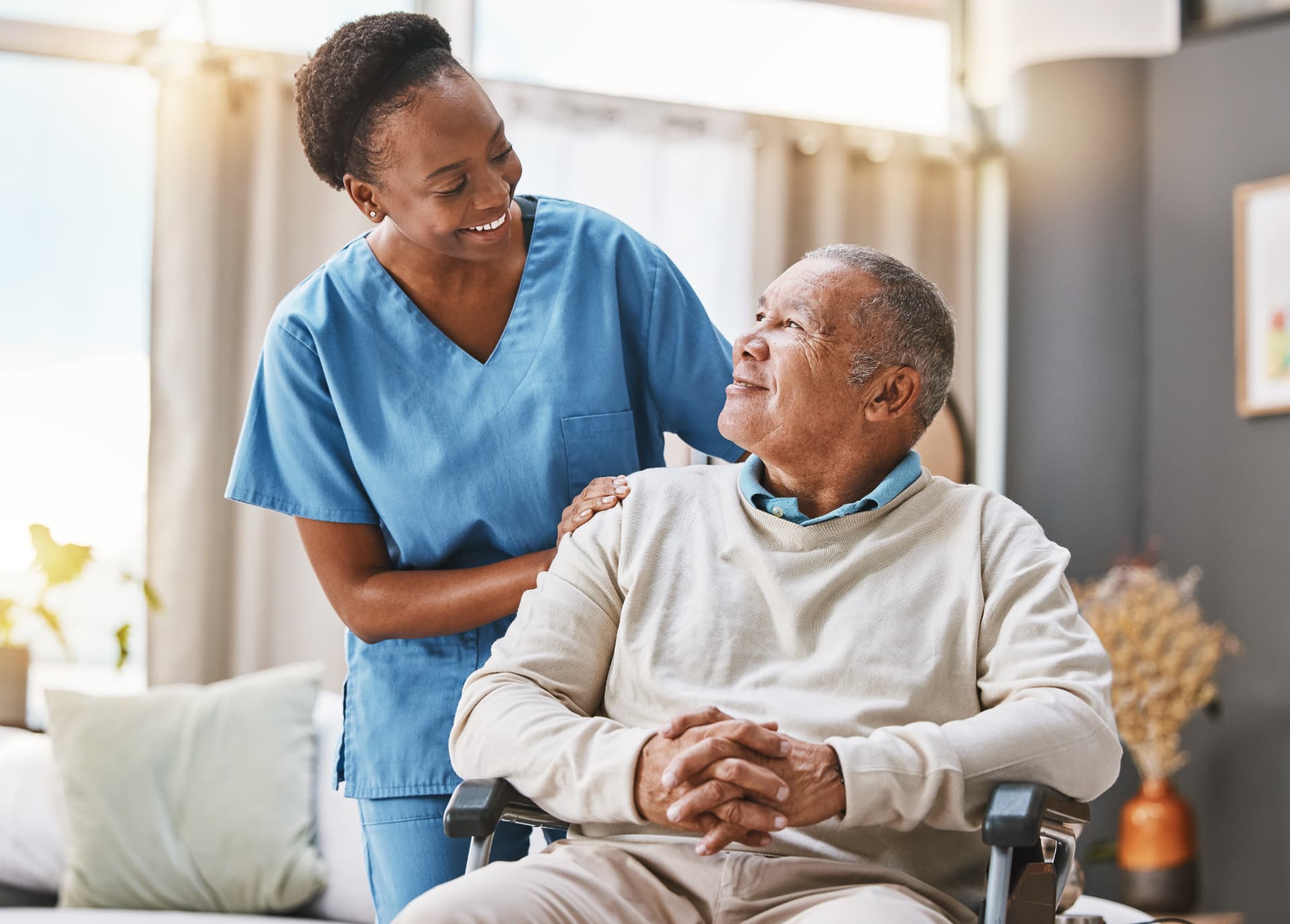 Nurse supporting an older patient in a home care setting